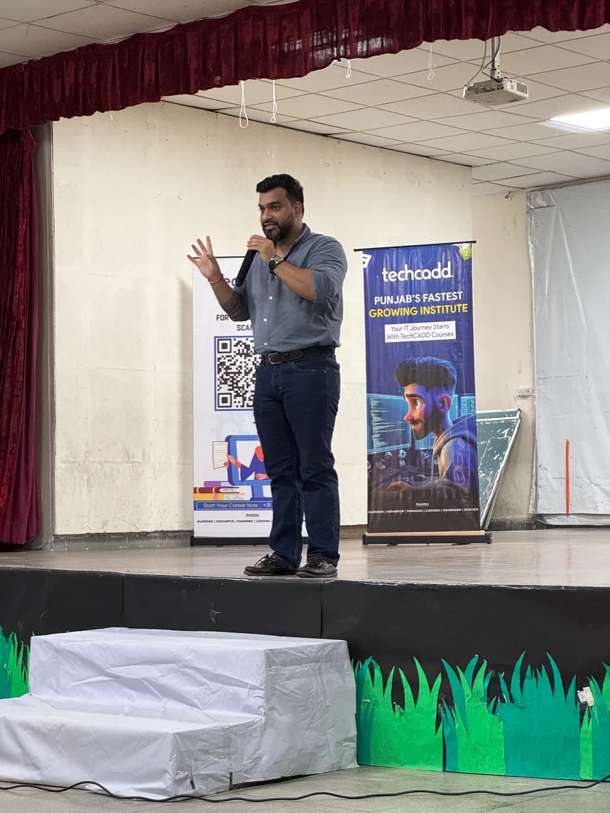 A TechCADD trainer addressing students on stage at the Hoshiarpur campus